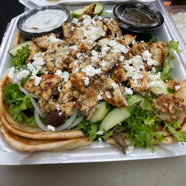 Caffé OPA's Greek chicken pita with feta, lettuce, cucumber, onions, and olives, with two sauces.